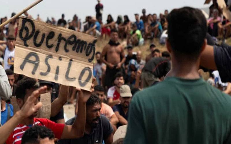Migrants chant slogans in Spain, refusing to go back to Morocco.