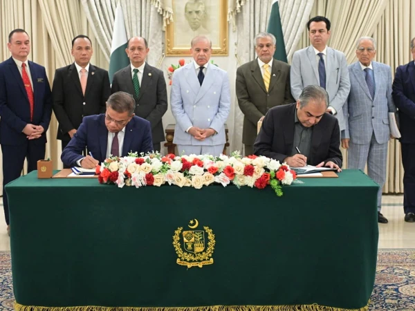 Prime Minister Shehbaz Sharif looks on as officials sign prisoner transfer agreement.