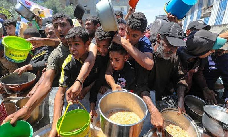 Children attempt to reach out to food at a distributed centre